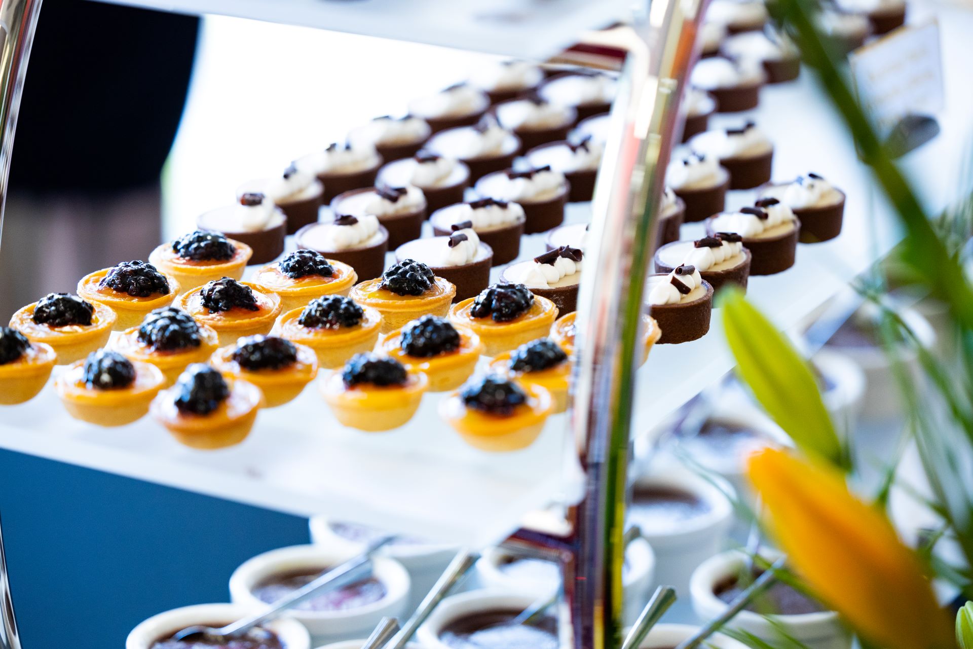 Yellow cookies topped with blackberries, alongside white cookies sprinkled with chocolate